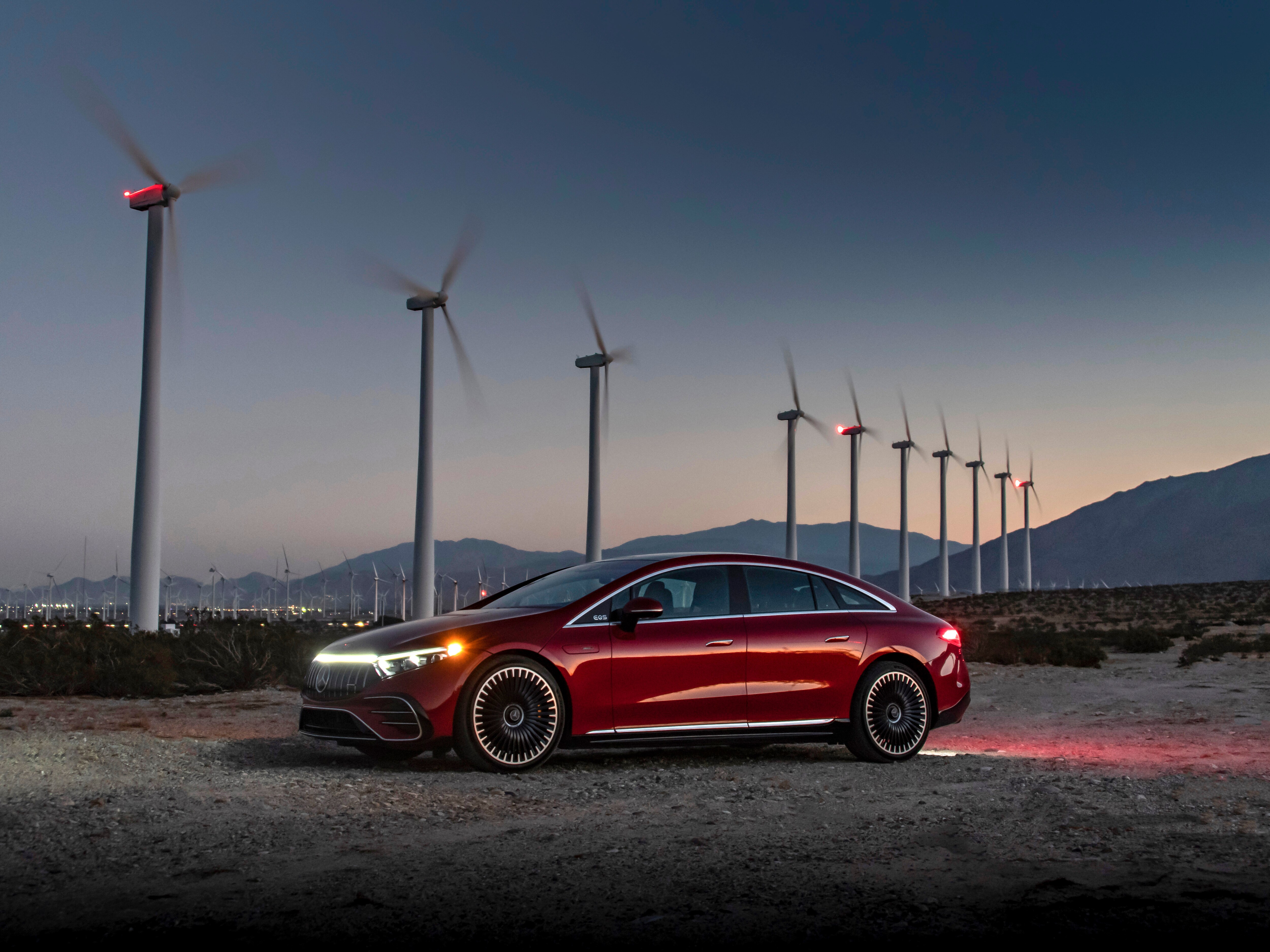 A red EQS parked in front of wind turbines