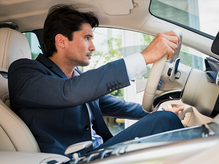 A man at the wheel of a Mercedes-Benz vehicle.