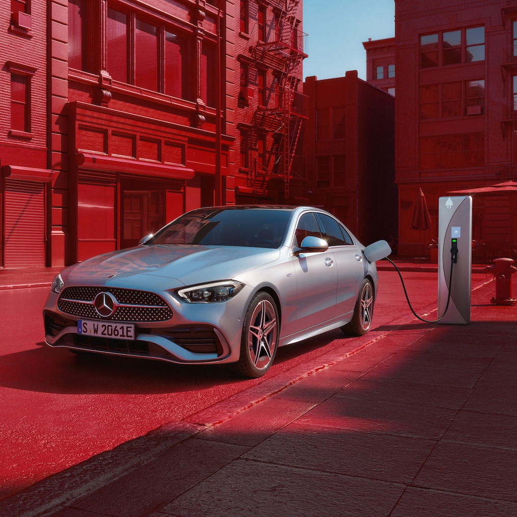 Dynamic view of a Mercedes-Benz C-Class Saloon (driving shot) or standing at a charging station.