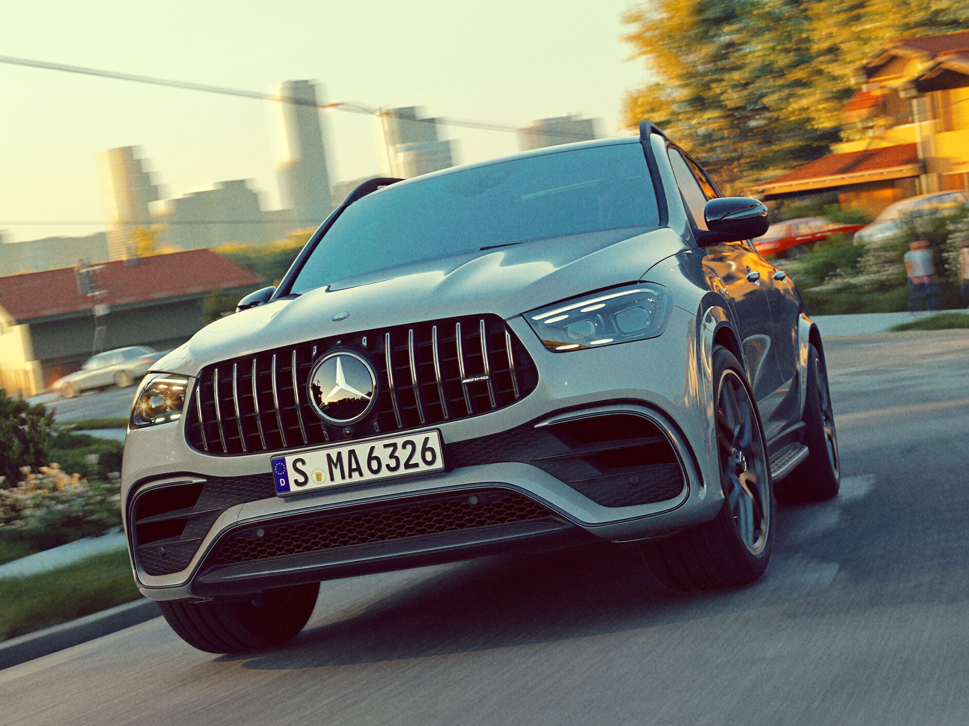 The GLE SUV from Mercedes-AMG in a front view driving on a road with the skyline in the background.