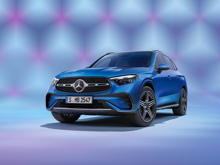 The image shows the angled front view of a Mercedes-Benz GLC in a blue studio.