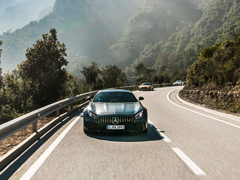 Three Mercedes-AMG models on a race track.