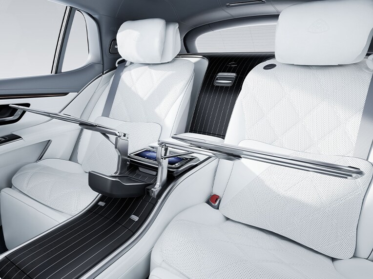 Folding tables in the rear interior of the luxury Mercedes-Maybach EQS SUV.