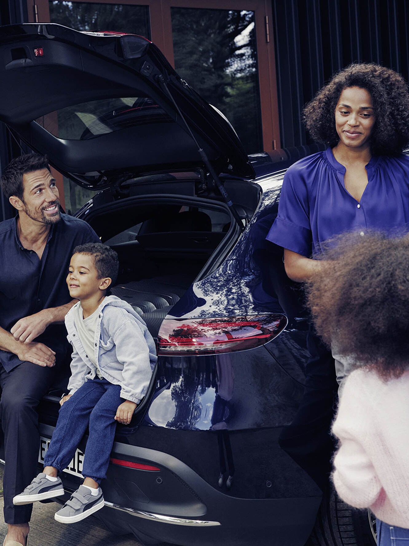 Family preparing their blue Mercedes-Benz EQC for a trip