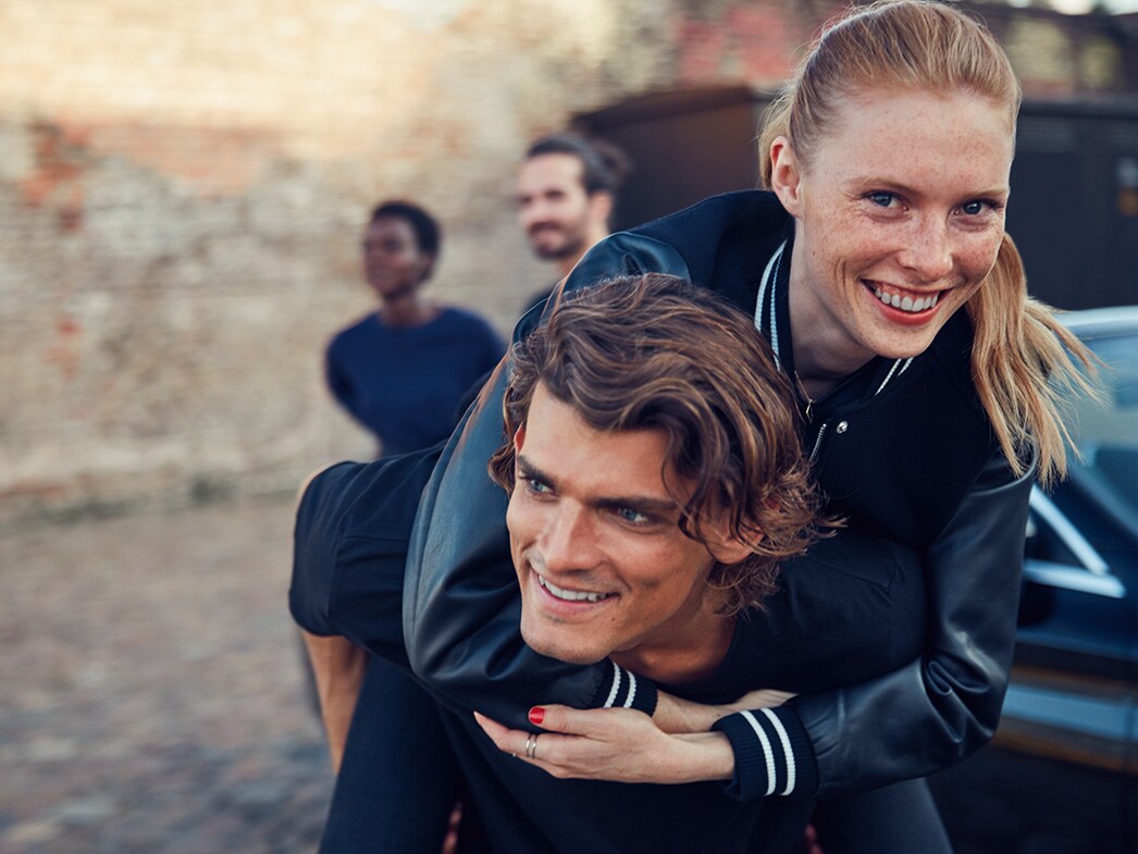 Several persons getting out of a Mercedes-Benz vehicle.