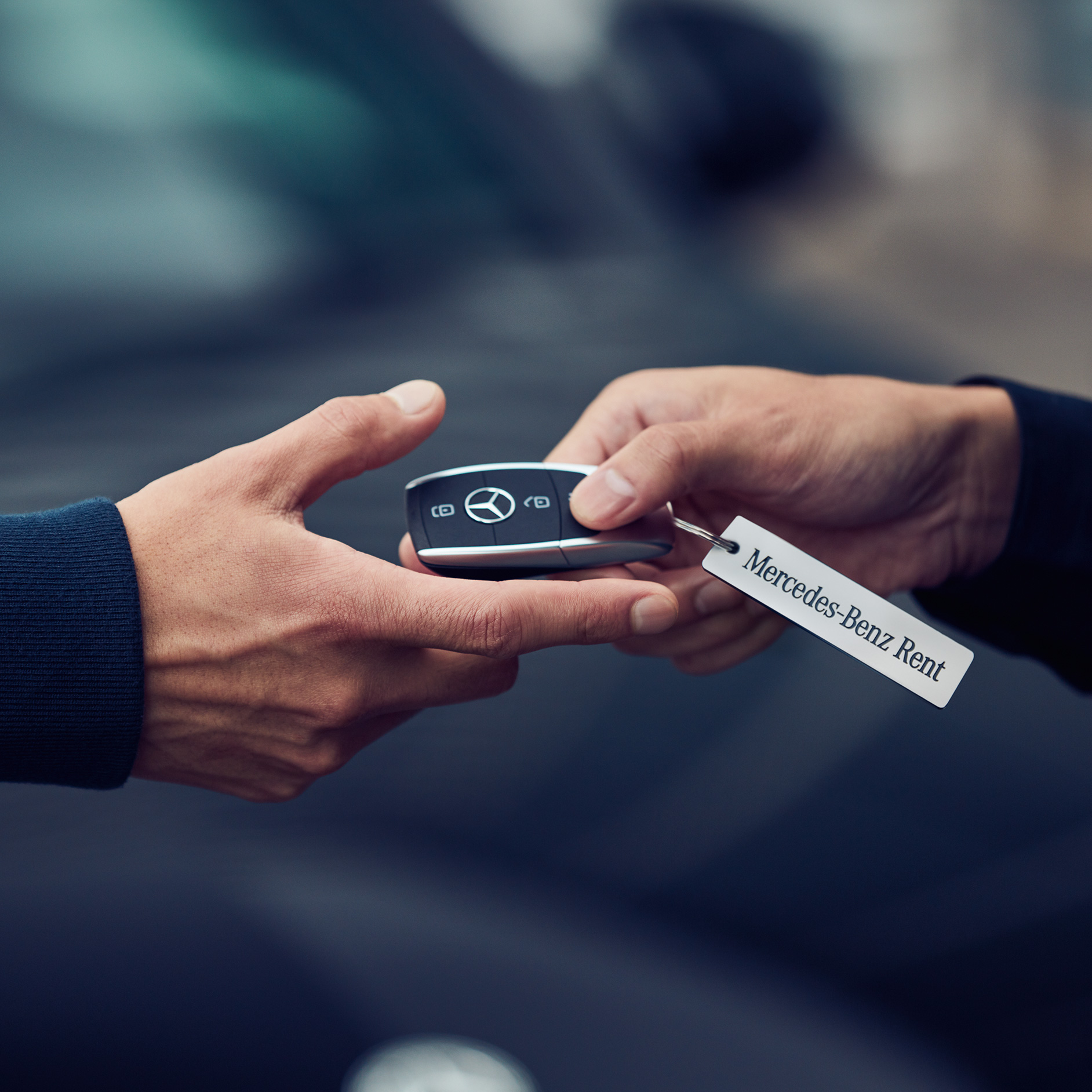 Rent | Financial Services | Mercedes-Benz Two hands passing each other a key from Mercedes-Benz.