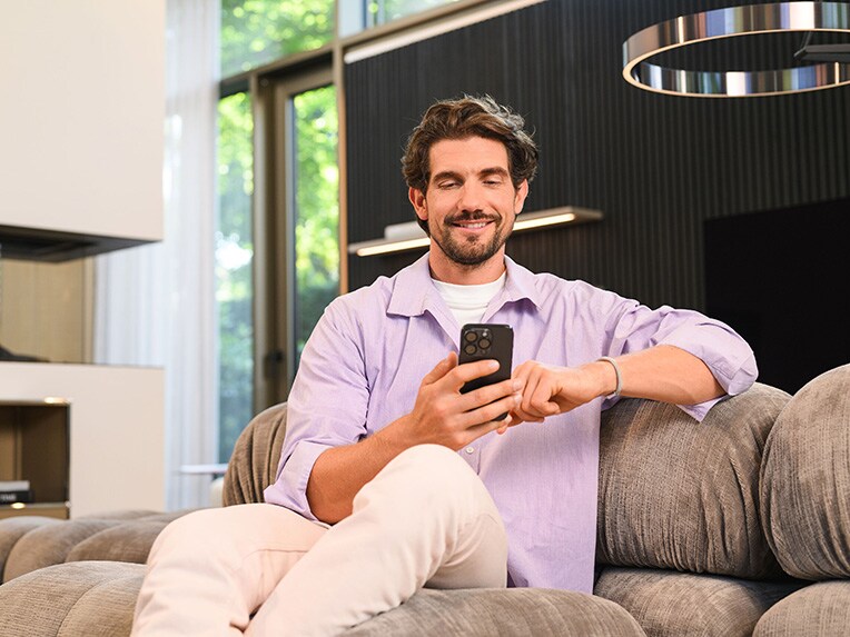 A person sitting on the couch using their mobile device.