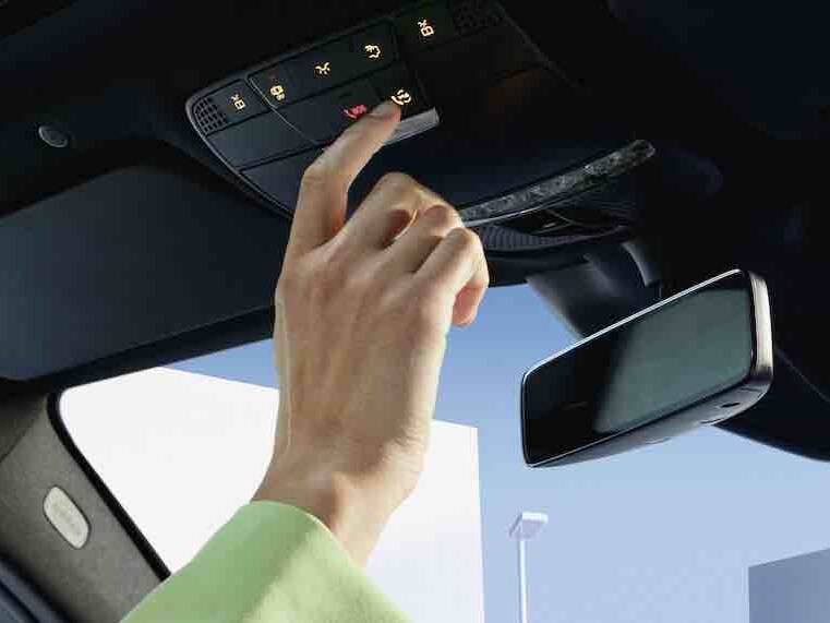 The Mercedes me button being pressed in the overhead control panel of a Mercedes-Benz.
