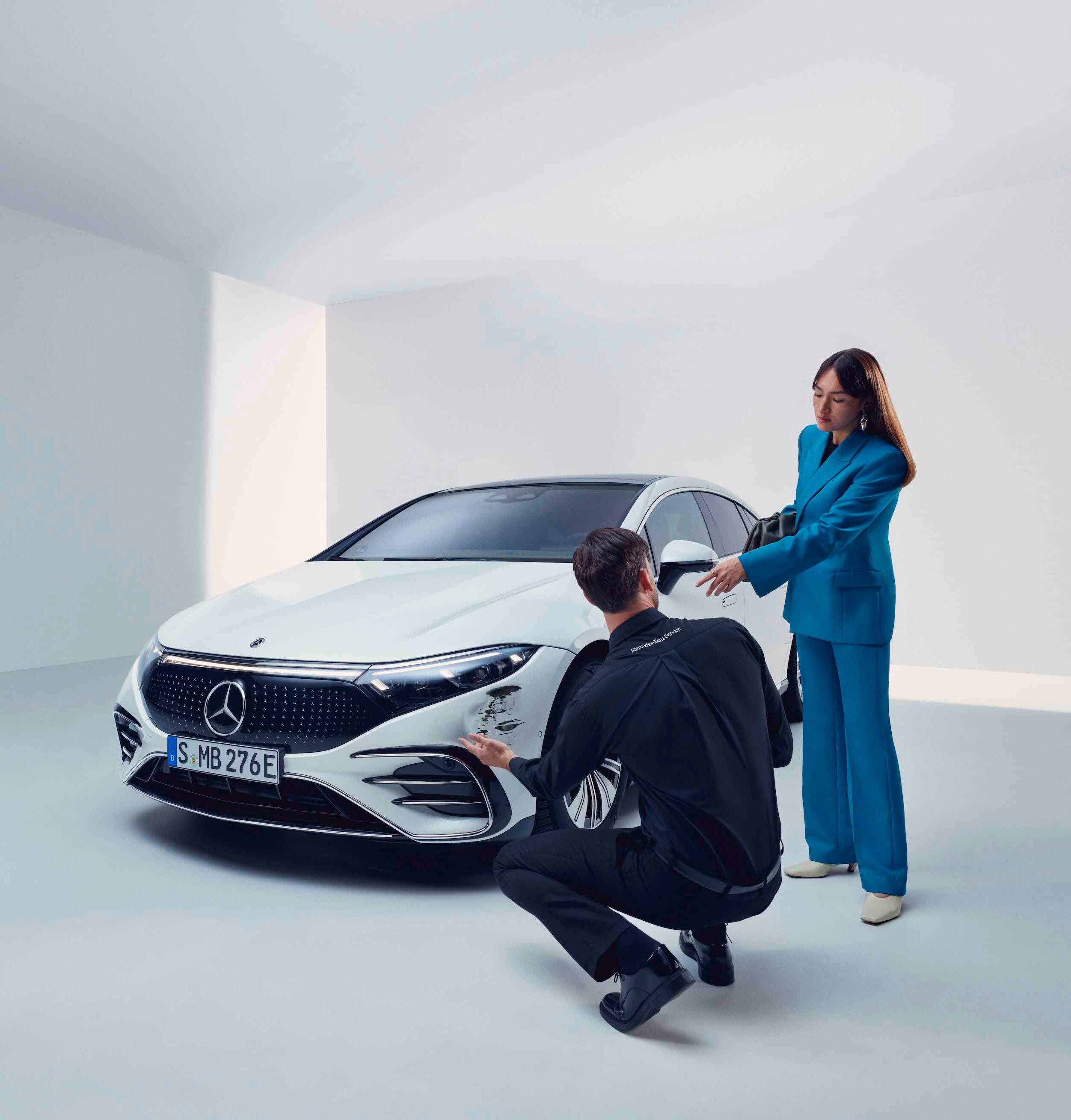 A woman having her Mercedes-Benz checked out by a service employee.