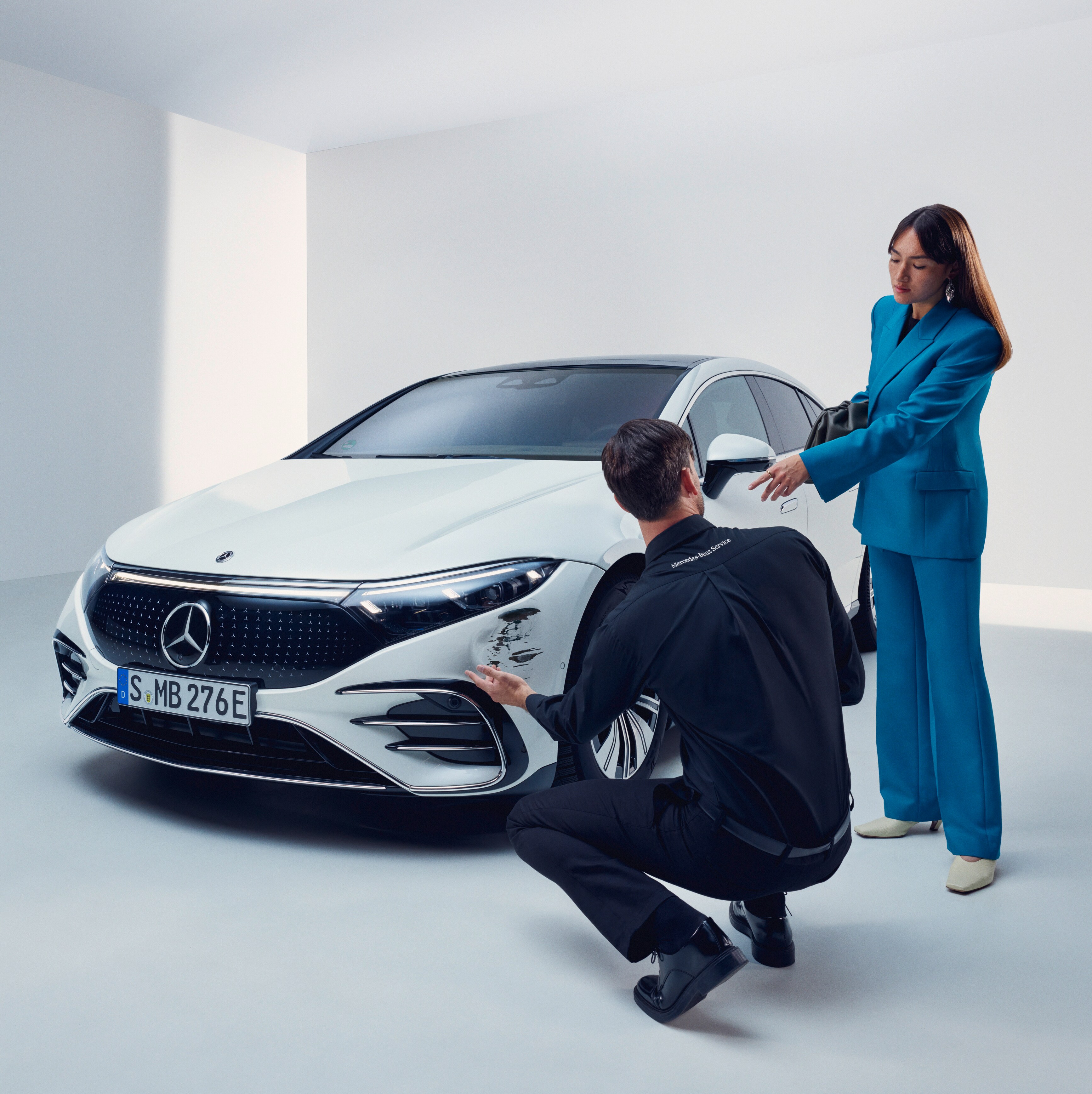 A man inspecting a womans Mercedes-Benz.