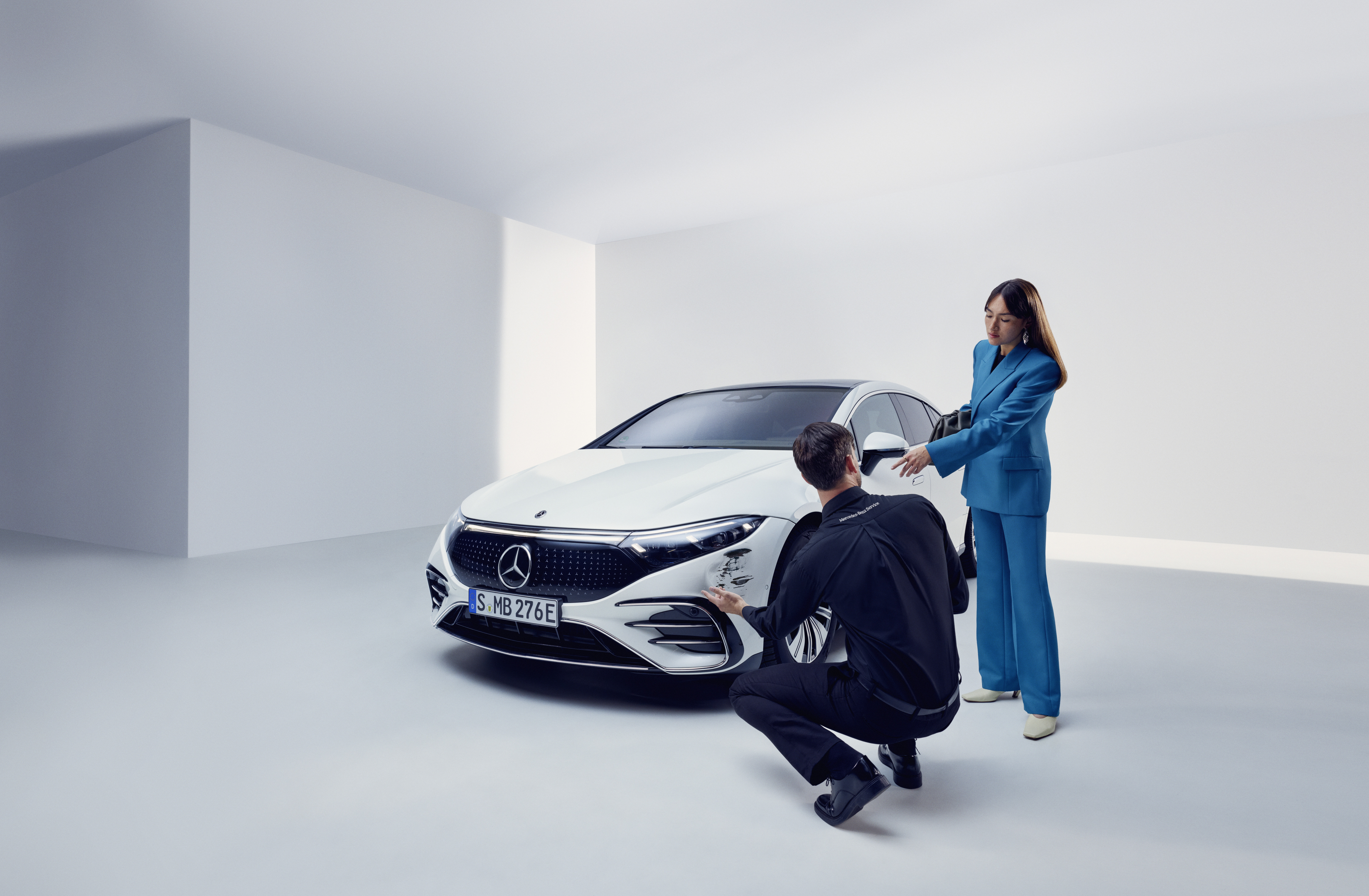 Damage report | Mercedes-Benz A man inspecting a womans Mercedes-Benz.