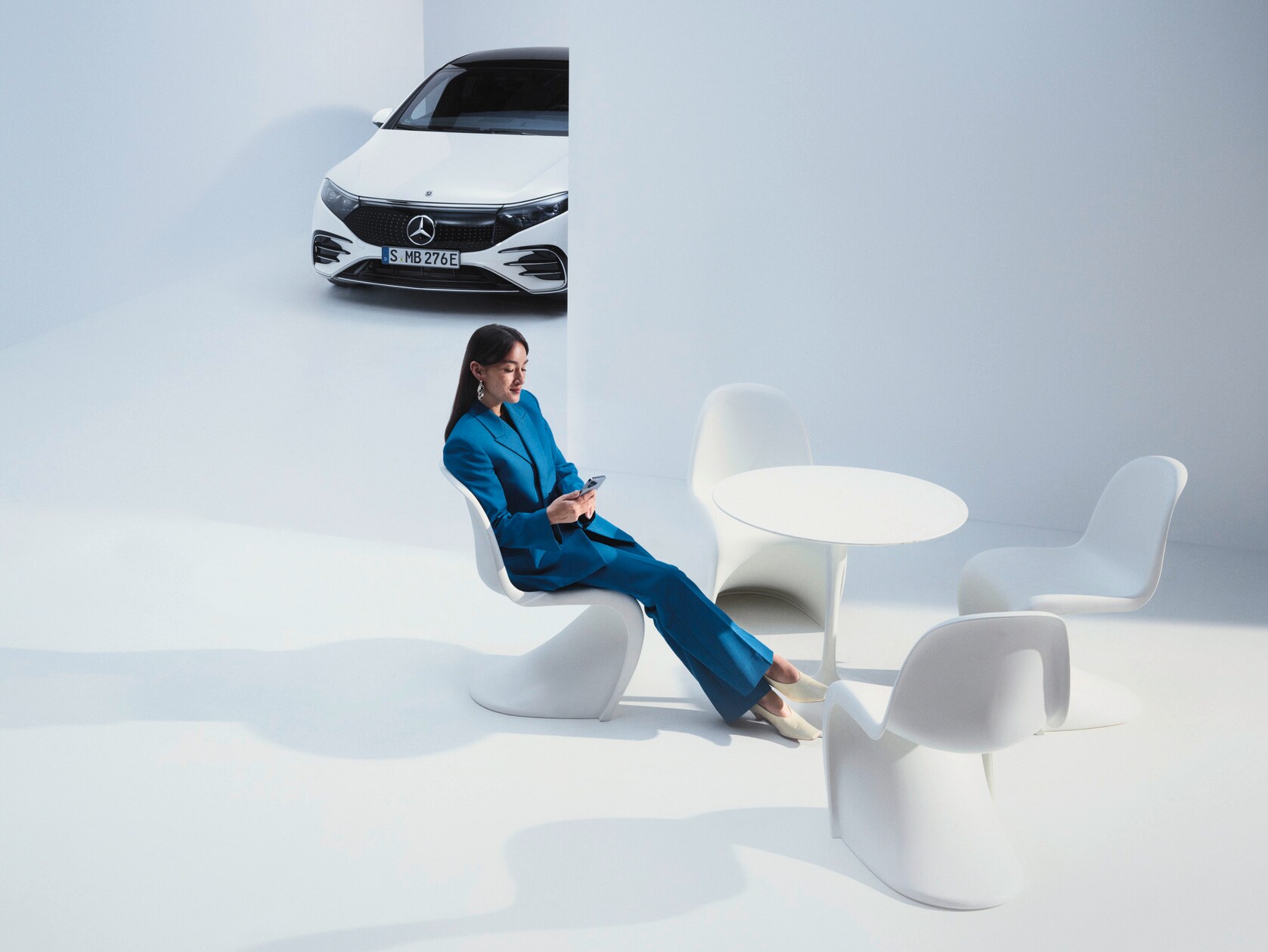 Woman on a call in front of her Mercedes