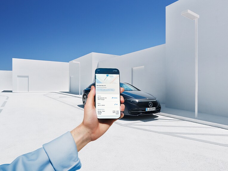 Someone holding a smartphone connected to a Mercedes-Benz through Digital Extras.