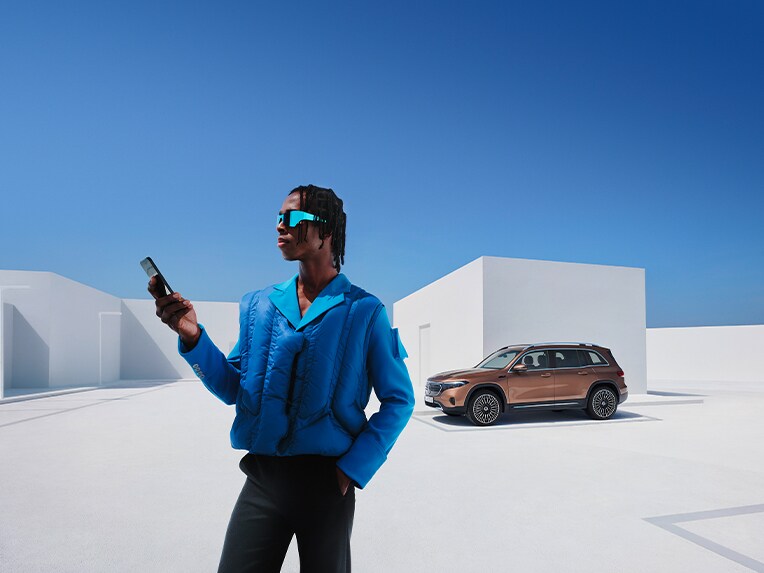 Man connected to the Mercedes-Benz with his smartphone.