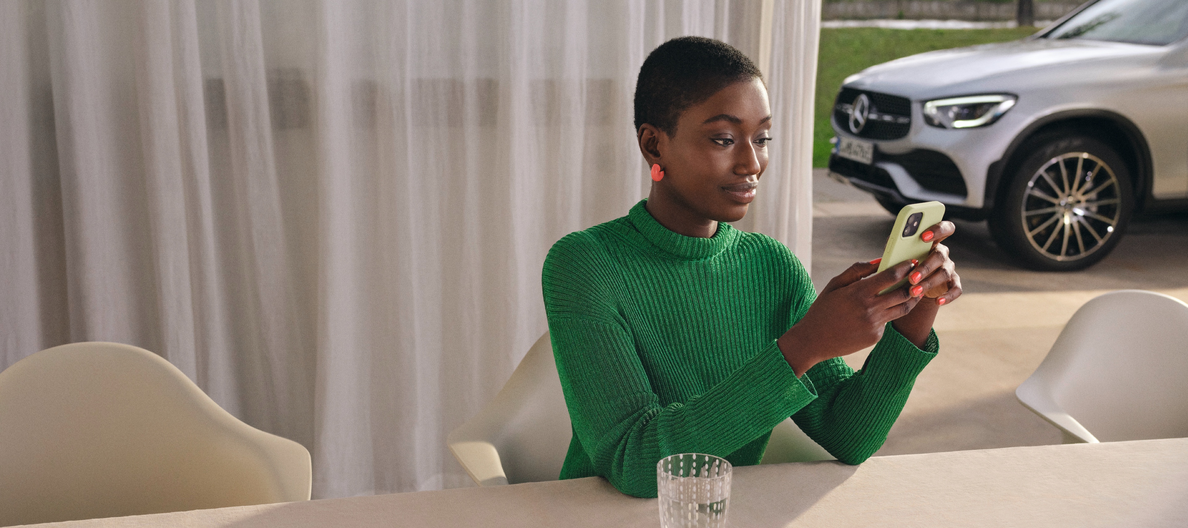A woman checks the status of her vehicle on her smartphone. A woman checks the status of her vehicle on her smartphone.