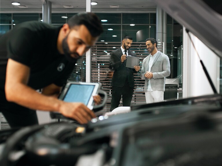 A Mercedes-Benz technician checks the vehicle's electrical system battery.
