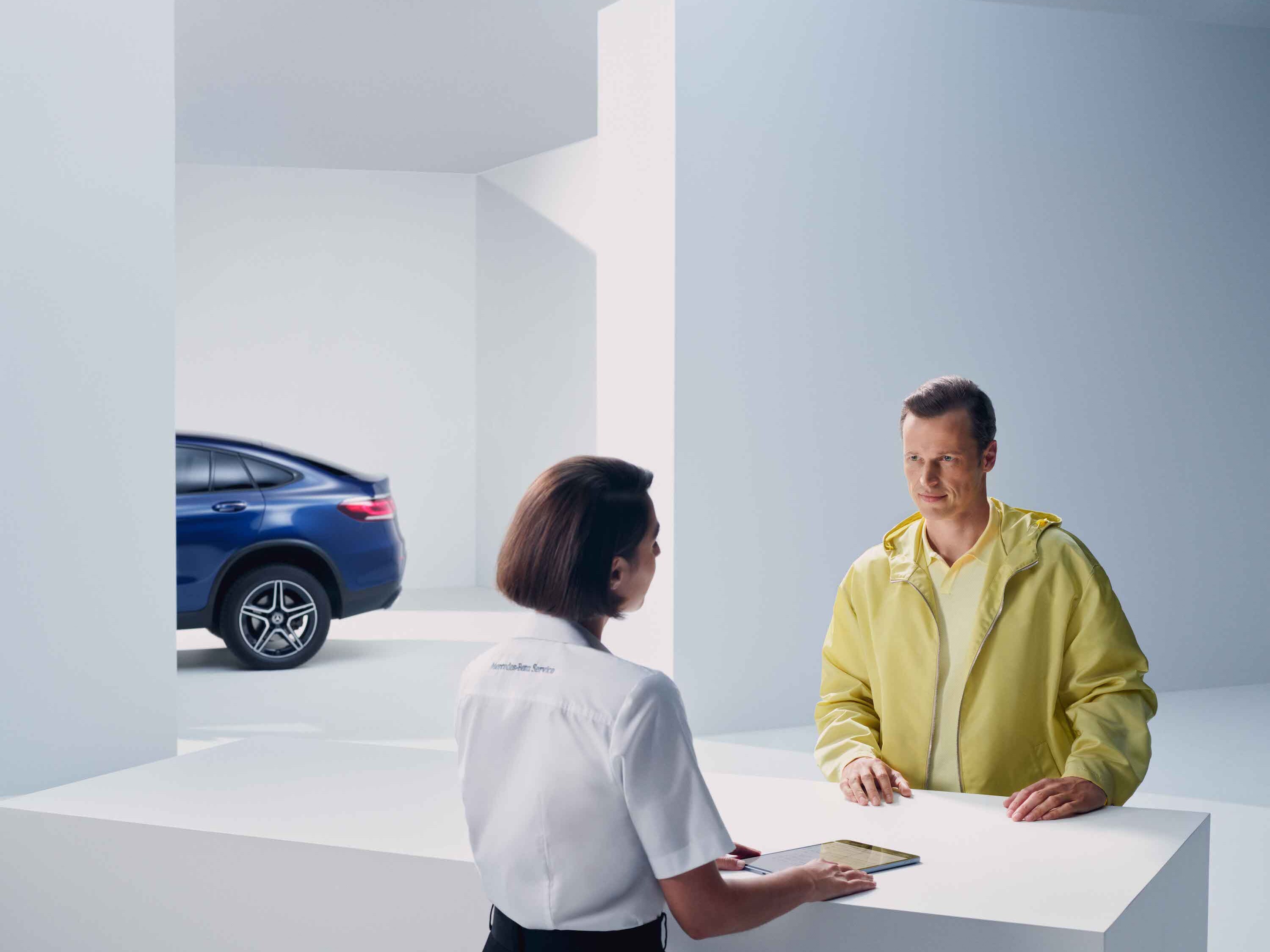 A person gets advice from a Mercedes-Benz employee.