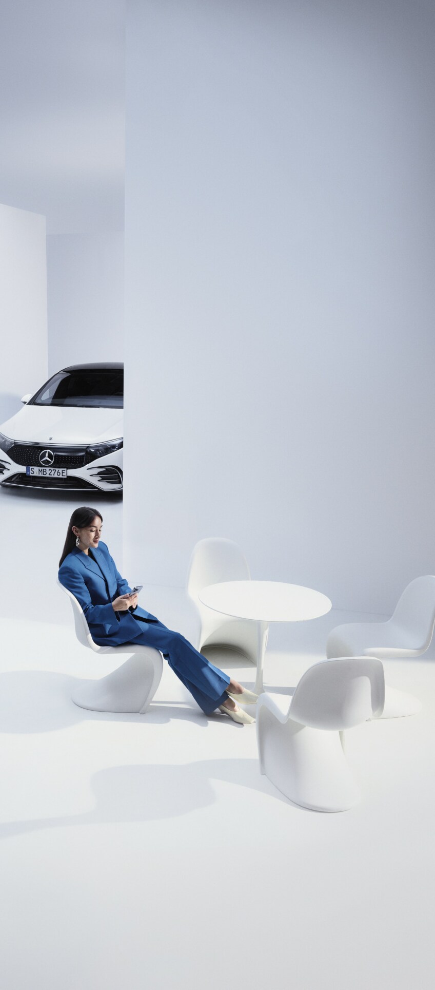 A customer leaning at the counter turns expectantly to face a Mercedes-Benz employee.