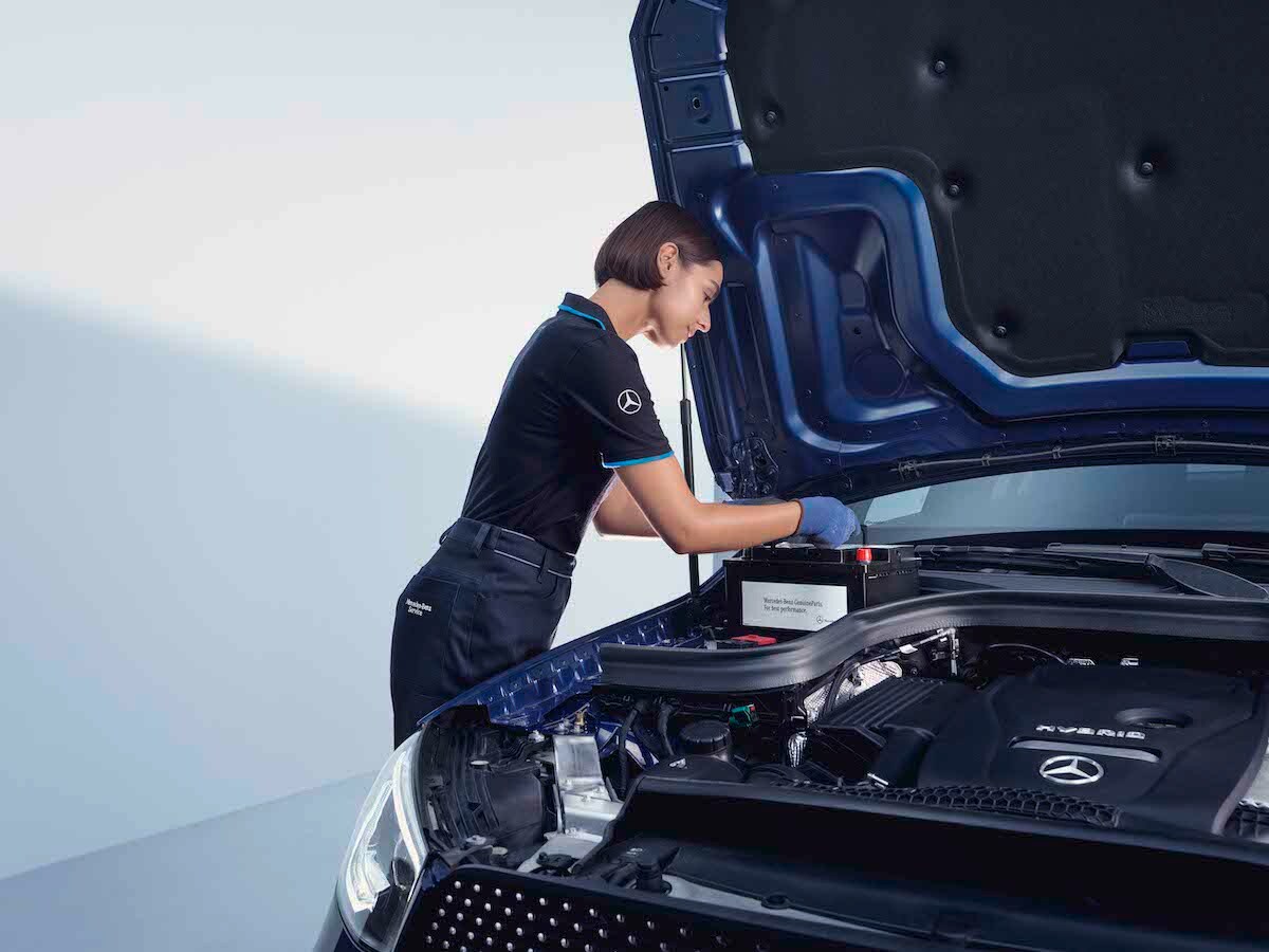 A Mercedes-Benz technician checks a car battery.