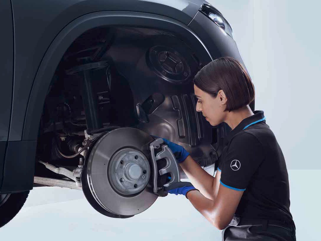 A Mercedes-Benz technician checks the brakes of a vehicle.