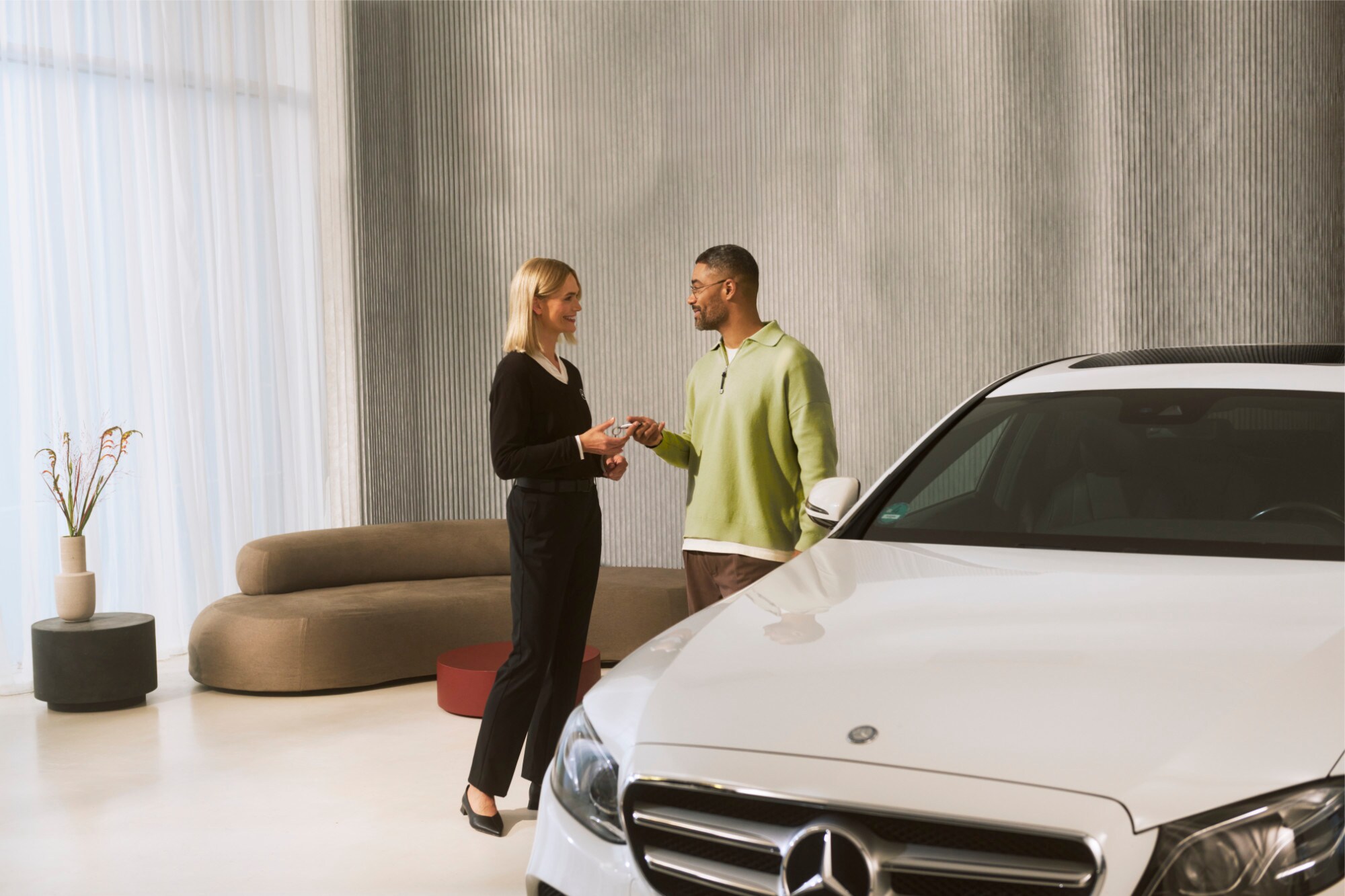 A Mercedes-Benz consultant handing over vehicle keys to a customer.