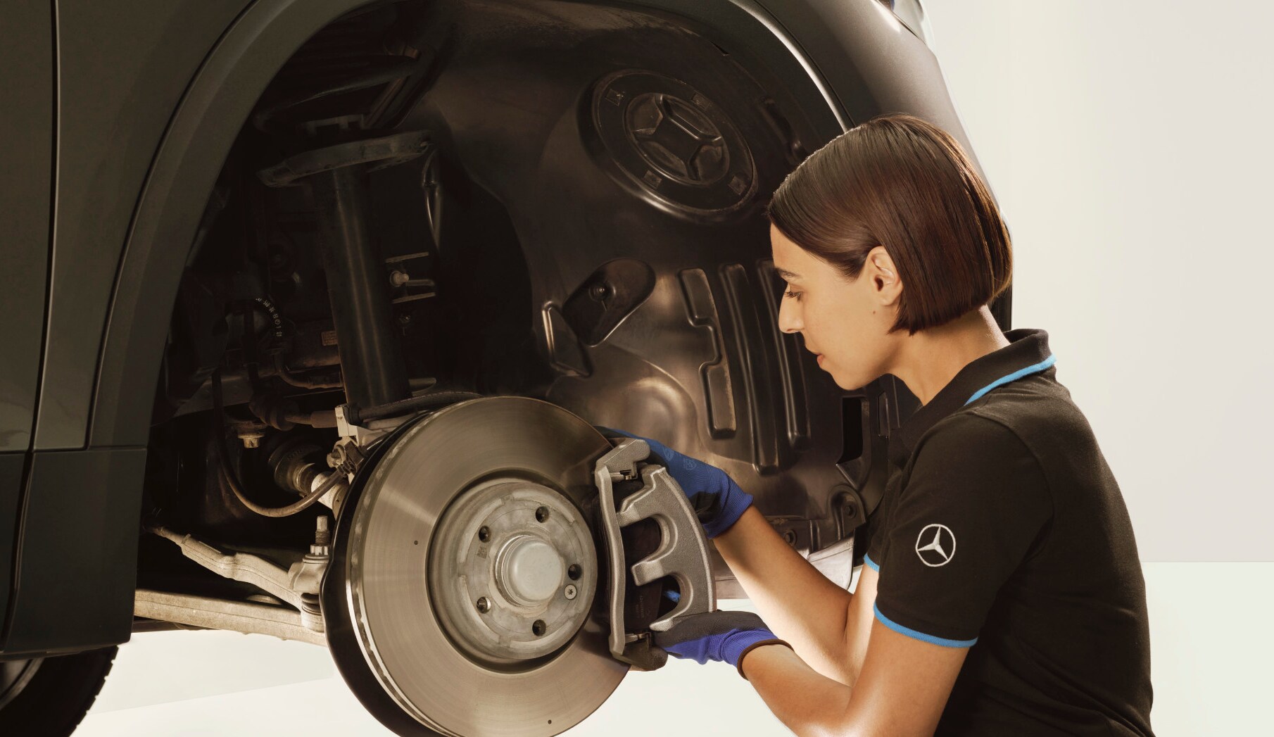 A technician repairing the brakes of a Mercedes-Benz vehicle.
