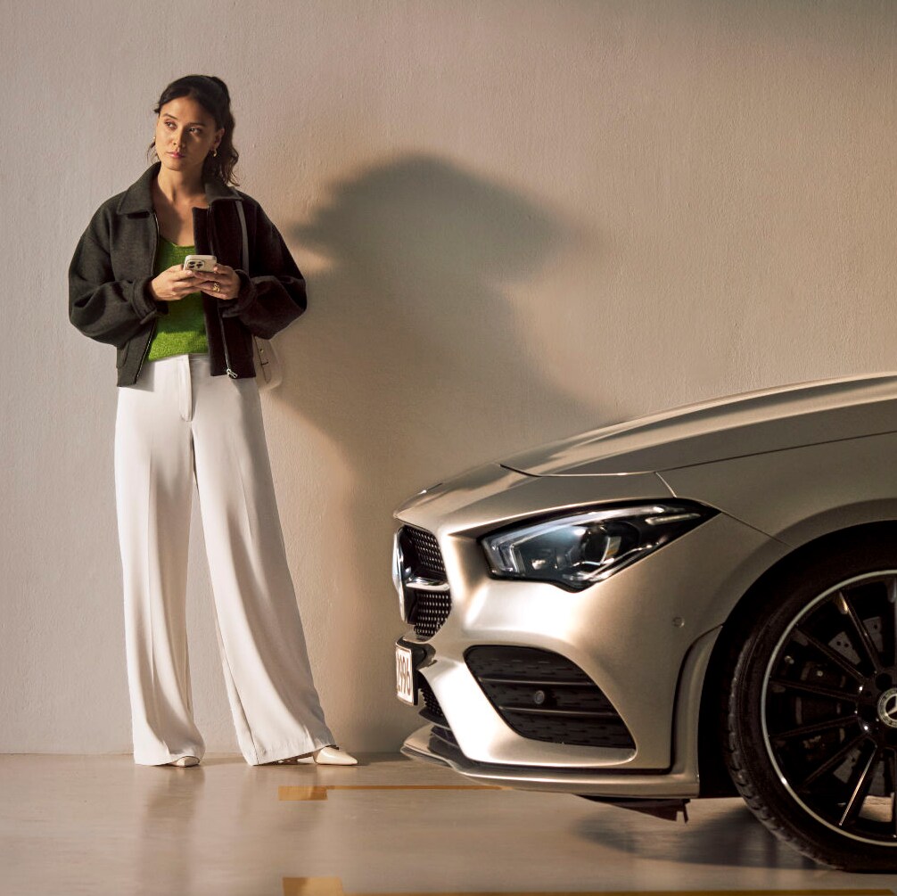 Person enjoying the benefits of getting a Mercedes-Benz serviced behind them
