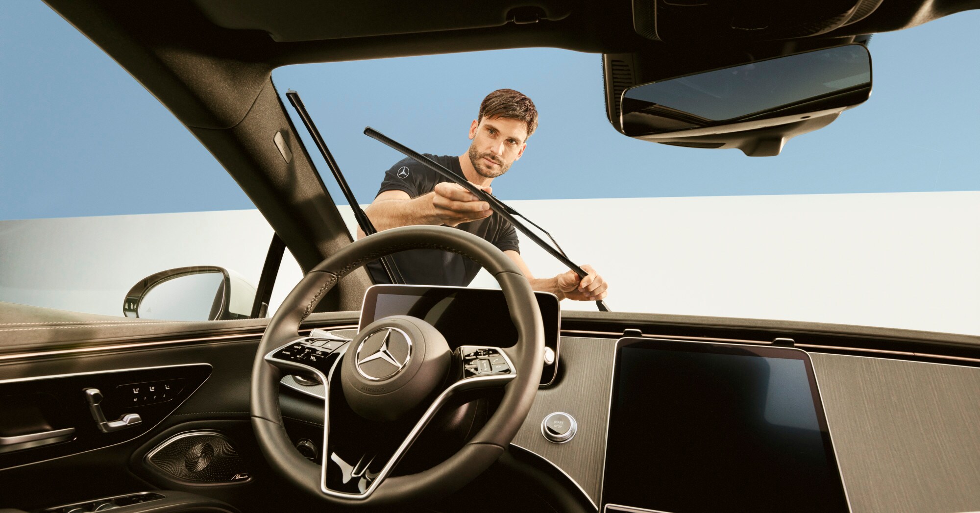 A technician repairing the wiper blades of a Mercedes-Benz vehicle.