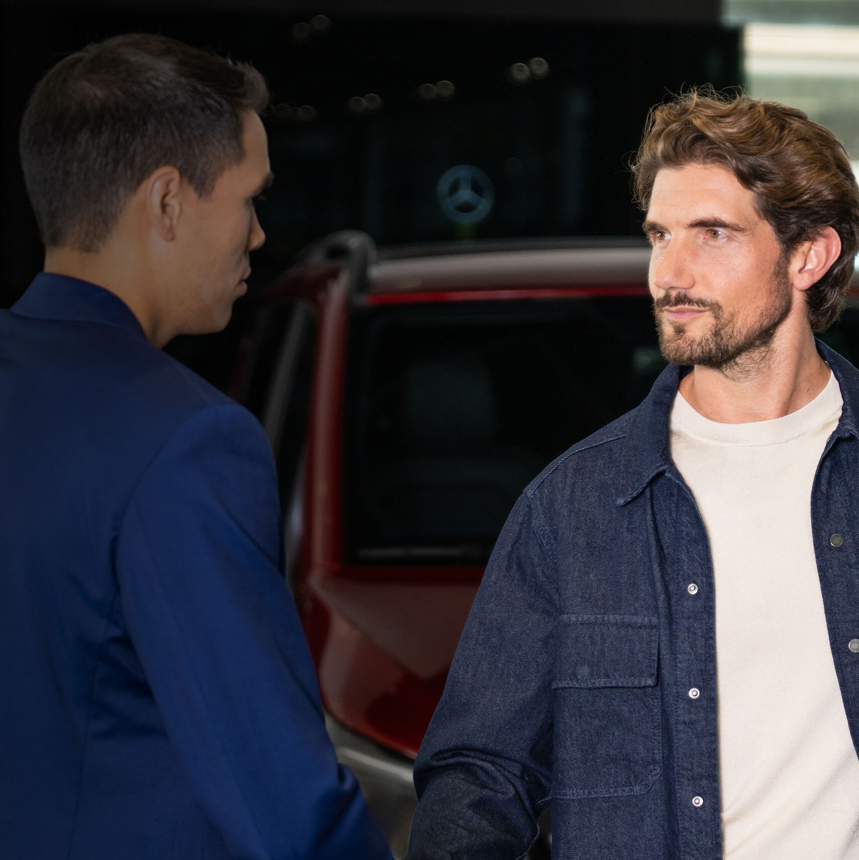 Two men having a chat in front of a Mercedes-Benz Vans