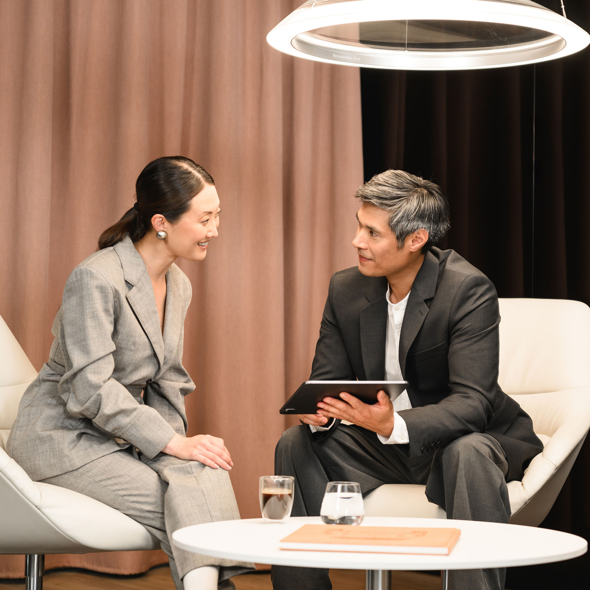 Novated Leasing A man holding tablet having a discussion with a woman