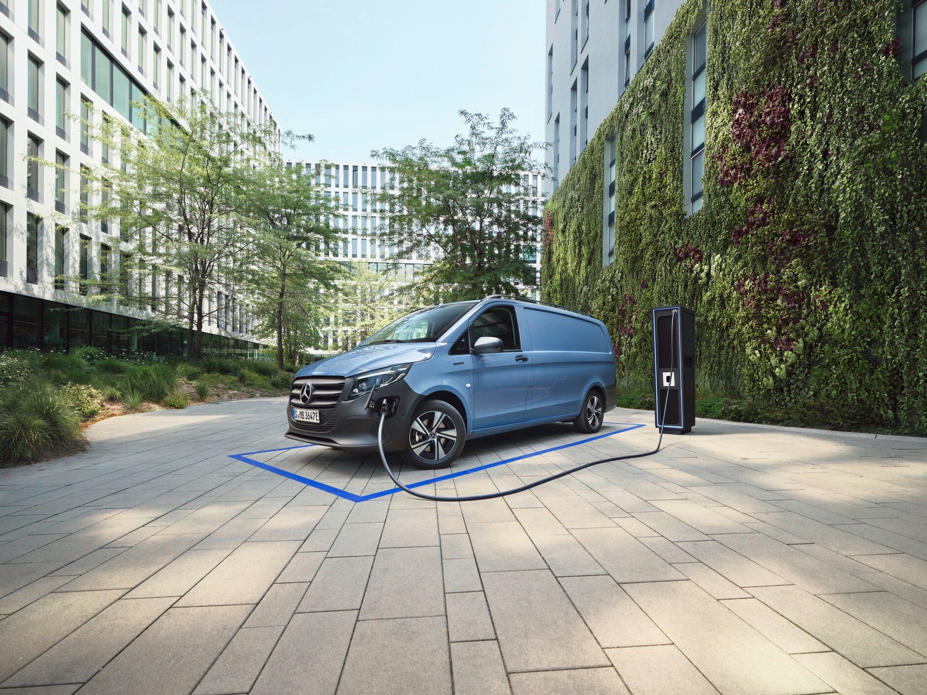 The eVito Panel Van standing in a parking space next to a charging station.