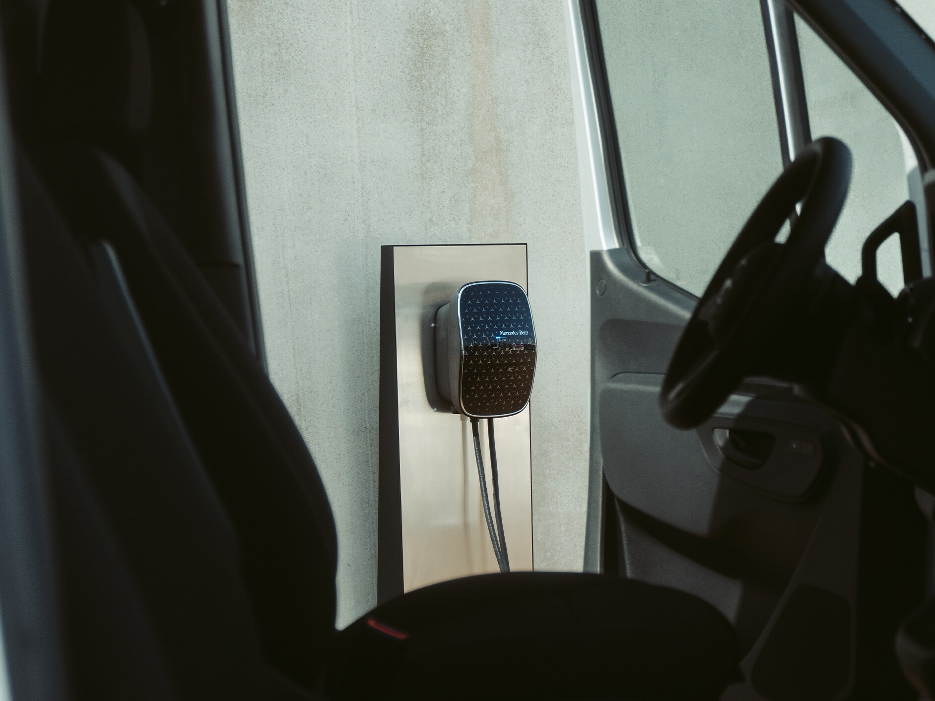 A Mercedes-Benz electric commercial van charging at a Mercedes-Benz Wallbox.