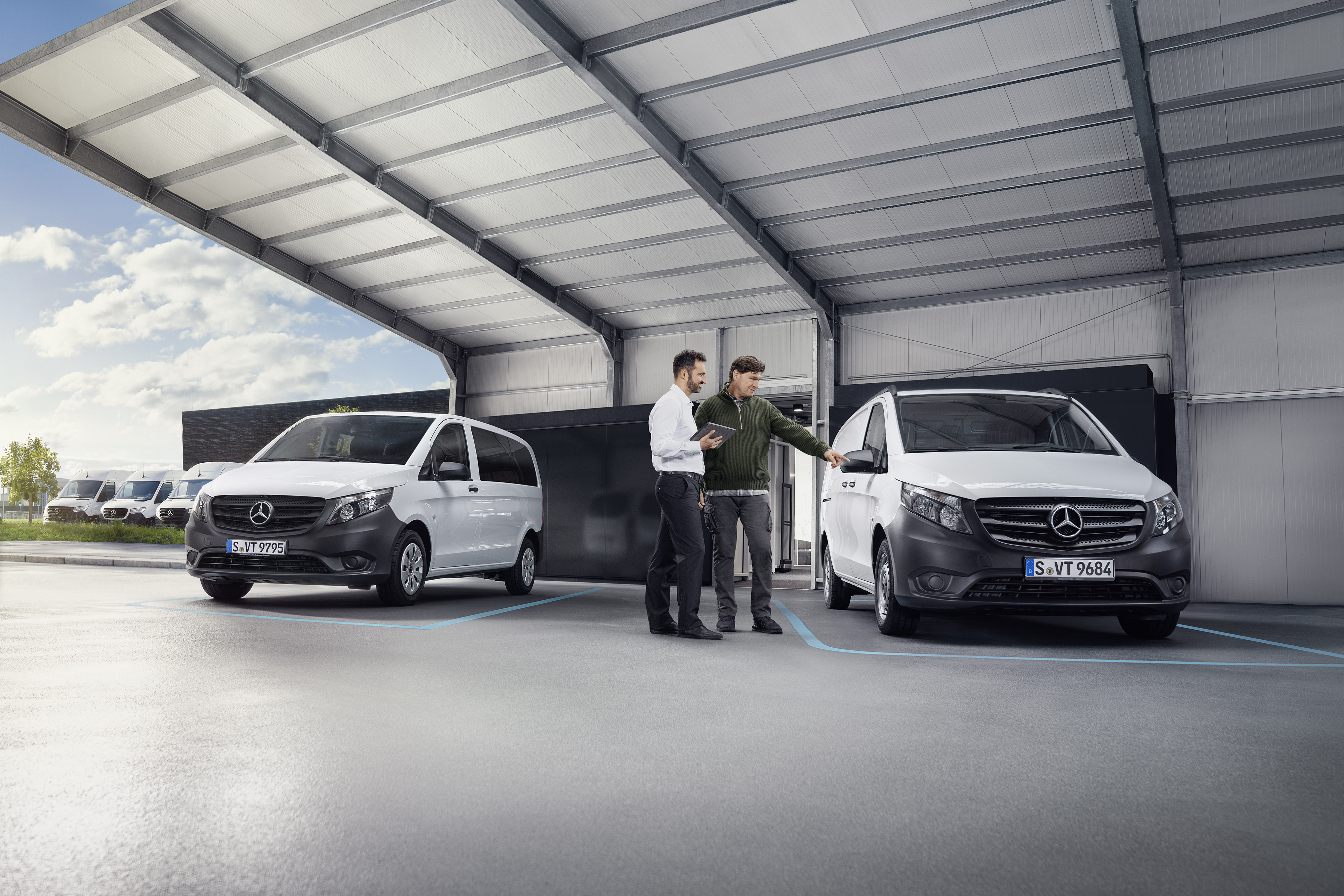 Mercedes-Benz | Recall Mercedes-Benz customer support agent with client in a service partner location in front of a van.